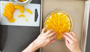 Placing peaches on tart
