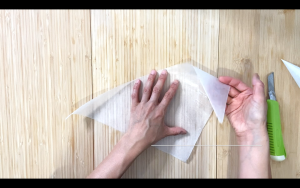 Take one corner and roll it toward the center.